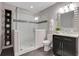 Bathroom featuring a glass enclosed shower, dark cabinets, and a decorative mirror at 4550 Lois Se St, Smyrna, GA 30080