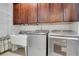 Functional laundry room with modern Maytag washer and dryer, upper cabinets, and utility sink at 4550 Lois Se St, Smyrna, GA 30080