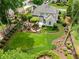 Stunning aerial view of an estate featuring a lush backyard with a firepit and beautiful landscaping at 725 Heathland Dr, Roswell, GA 30075