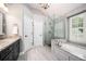 Bathroom featuring a glass shower, soaking tub, and double sink vanity at 725 Heathland Dr, Roswell, GA 30075