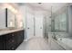 Bathroom featuring a glass shower, soaking tub, and double sink vanity at 725 Heathland Dr, Roswell, GA 30075