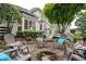 Outdoor stone firepit surrounded by Adirondack chairs, creating a cozy gathering space in a landscaped backyard at 725 Heathland Dr, Roswell, GA 30075