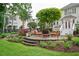 Paver patio with outdoor seating, steps leading to a manicured lawn, and lush landscaping at 725 Heathland Dr, Roswell, GA 30075