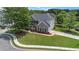 An aerial view of a two-story brick home with a well-manicured lawn and mature trees at 2023 Arbor Springs Way, Buford, GA 30519
