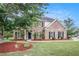 Charming brick two-story home with manicured lawn and black shutters at 2023 Arbor Springs Way, Buford, GA 30519
