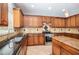 Kitchen featuring stainless steel appliances, dark countertops and brown cabinets at 2023 Arbor Springs Way, Buford, GA 30519