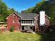 A spacious backyard featuring a brick house with a deck, porch, stairs, and plenty of greenery at 5618 Highway 212, Covington, GA 30016
