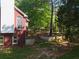 Brick home showcasing a backyard with a terraced garden and mature trees at 5618 Highway 212, Covington, GA 30016