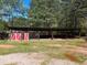 Rustic barn structure with red and white doors, providing ample open space and shelter at 5618 Highway 212, Covington, GA 30016