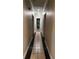 Long hallway with black and beige decorative tiled floors and neutral wall color at 5618 Highway 212, Covington, GA 30016