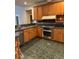 Traditional kitchen with wood cabinets, stainless steel appliances and green tile floor at 5618 Highway 212, Covington, GA 30016
