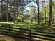 Wood fence in the back of the lot leads into wooded area with mature trees at 5618 Highway 212, Covington, GA 30016
