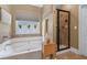 Bright bathroom featuring a soaking tub, a glass enclosed shower, and decorative accents at 1645 Horseshoe Creek Ln, Cumming, GA 30041