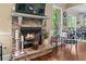 Cozy fireplace featuring a stone hearth, decorative mantel, hardwood floors, and a view to the backyard at 1645 Horseshoe Creek Ln, Cumming, GA 30041