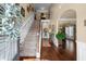 Grand foyer with hardwood floors, staircase, and arched doorways creating an elegant and welcoming entryway at 1645 Horseshoe Creek Ln, Cumming, GA 30041