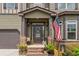 Inviting front porch with decorative columns, elegant front door with glass accents and seasonal decor with stylish outdoor lighting at 1645 Horseshoe Creek Ln, Cumming, GA 30041