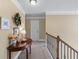 Upstairs hallway with decorative table, crown molding, and neutral tones, leading to various rooms at 1645 Horseshoe Creek Ln, Cumming, GA 30041