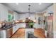 Modern kitchen features stainless appliances, granite counters, white cabinets, tile backsplash, and hardwood floors at 1645 Horseshoe Creek Ln, Cumming, GA 30041