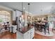 Open kitchen featuring stainless appliances, granite counters, island, white cabinets, and hardwood floors at 1645 Horseshoe Creek Ln, Cumming, GA 30041