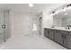 Bright bathroom featuring double vanity, gray cabinets, white marble floors and glass shower at 2722 Byess Ct, Marietta, GA 30064
