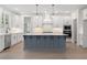 Eat-in kitchen boasts white cabinets, stainless steel appliances, pendant lighting, and a large island at 2722 Byess Ct, Marietta, GA 30064