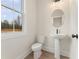 Bright powder room featuring a pedestal sink, oval mirror, and a window providing natural light at 2722 Byess Ct, Marietta, GA 30064