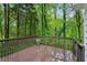 Wood deck surrounded by lush green trees and foliage with wood railings at 2986 Edenberry Nw Ln, Kennesaw, GA 30152