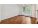 Spacious empty room features hardwood floors and a window, offering a blank canvas for personalization at 2986 Edenberry Nw Ln, Kennesaw, GA 30152