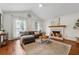 Cozy living room with vaulted ceilings, a brick fireplace, and hardwood floors at 2986 Edenberry Nw Ln, Kennesaw, GA 30152
