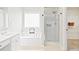 Bathroom showcasing a soaking tub, separate glass-enclosed shower, and walk-in closet access at 3168 Kirkwood Nw Dr, Kennesaw, GA 30144