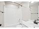 Bright bathroom with white tiled shower and tub combination with single sink vanity and chrome fixtures at 3168 Kirkwood Nw Dr, Kennesaw, GA 30144
