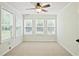 Bright, carpeted bedroom featuring a ceiling fan and multiple windows for natural light at 3168 Kirkwood Nw Dr, Kennesaw, GA 30144