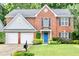 Charming brick home featuring a manicured lawn, blue door, and a two-car garage at 3168 Kirkwood Nw Dr, Kennesaw, GA 30144