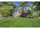 Charming two-story home with a well-manicured lawn, a blue front door, and lush landscaping at 3820 Pheasant Run Trce, Cumming, GA 30028
