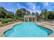 Community swimming pool with lounge chairs and shaded seating areas under a bright sky at 3820 Pheasant Run Trce, Cumming, GA 30028