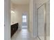 Spacious bathroom with dual vanity sinks, tile flooring, and a glass-enclosed shower at 406 Westmarch Cir, Loganville, GA 30052