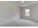 An empty room with neutral walls, carpet floors, and a window letting in natural light at 406 Westmarch Cir, Loganville, GA 30052