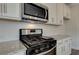 Close-up of a kitchen area, featuring stainless steel appliances and granite countertops at 406 Westmarch Cir, Loganville, GA 30052