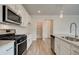 Well-equipped kitchen featuring white cabinets, granite countertops, stainless steel appliances, and wood floors at 406 Westmarch Cir, Loganville, GA 30052