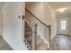 Stairway with carpeted steps and wood handrail leads to the upper level of the home at 406 Westmarch Cir, Loganville, GA 30052