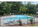 Fenced community pool surrounded by mature trees and lounge chairs for relaxing in the sun at 4234 Stillwater Dr, Duluth, GA 30096