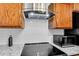 Close up of kitchen with stainless steel hood, granite countertops, tile backsplash, and wood cabinets at 4234 Stillwater Dr, Duluth, GA 30096