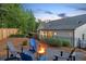 A cozy backyard with a fire pit surrounded by Adirondack chairs and professional landscaping at 141 Alaina Rd, Canton, GA 30115