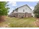 Exterior view of a home with a spacious backyard, green lawn, and mature trees at 2033 Millstream Holw, Conyers, GA 30012