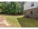 View of the lush backyard featuring green grass and wooded boundary line at 2033 Millstream Holw, Conyers, GA 30012