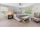Sunlit bedroom with a large bed, bench, neutral color palette, and windows overlooking greenery at 2033 Millstream Holw, Conyers, GA 30012