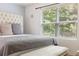 Bedroom showcasing a tufted headboard, bench, and large window with a view of the outdoors at 2033 Millstream Holw, Conyers, GA 30012