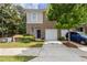 Charming two-story townhome with brick and siding, featuring an attached garage and well-maintained front yard at 2033 Millstream Holw, Conyers, GA 30012