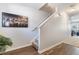 Bright hallway with wood floors leading to carpeted stairs and featuring a modern art piece at 2033 Millstream Holw, Conyers, GA 30012