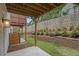 Landscaped backyard with a stone retaining wall and a patio beneath a wooden deck at 387 Skylar Se Way, Atlanta, GA 30315